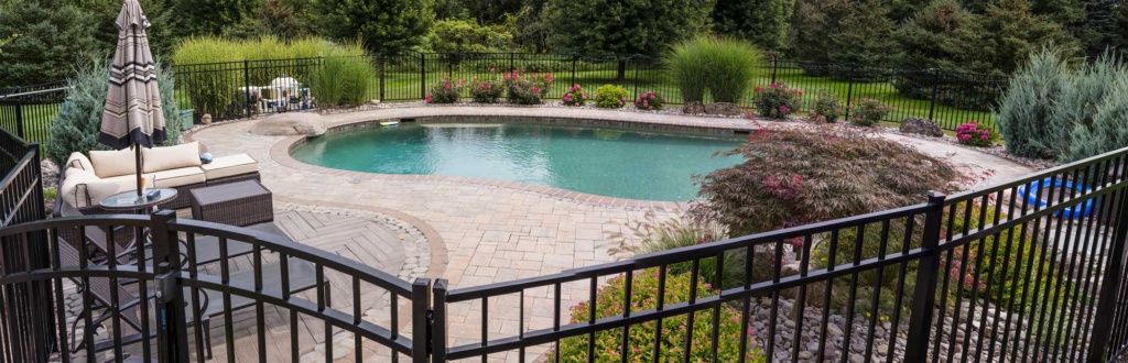 Pool surround, fence and plantings by Graf's Lawn &amp; Landscaping LLC